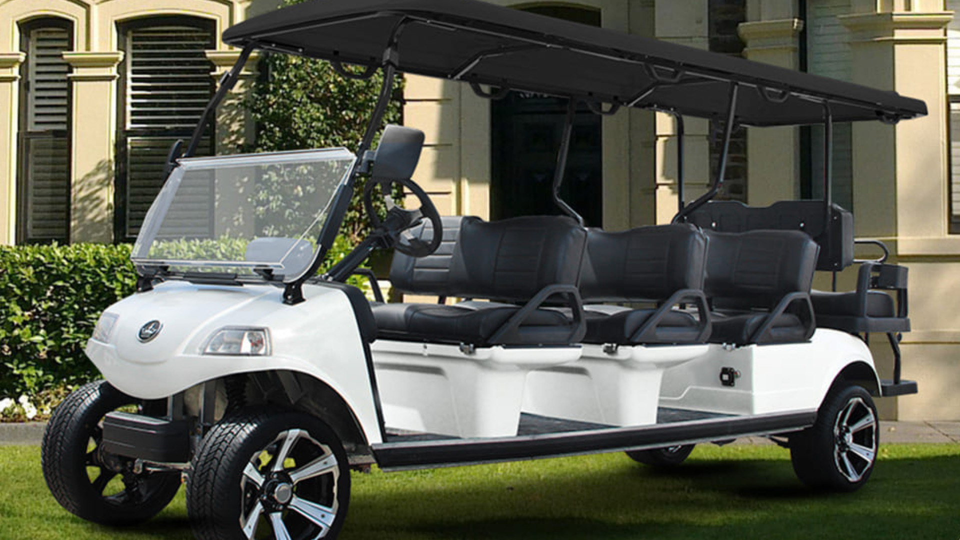 White six-passenger golf cart in Rancho Mission Viejo with black canopy, long seating layout, and polished wheels.