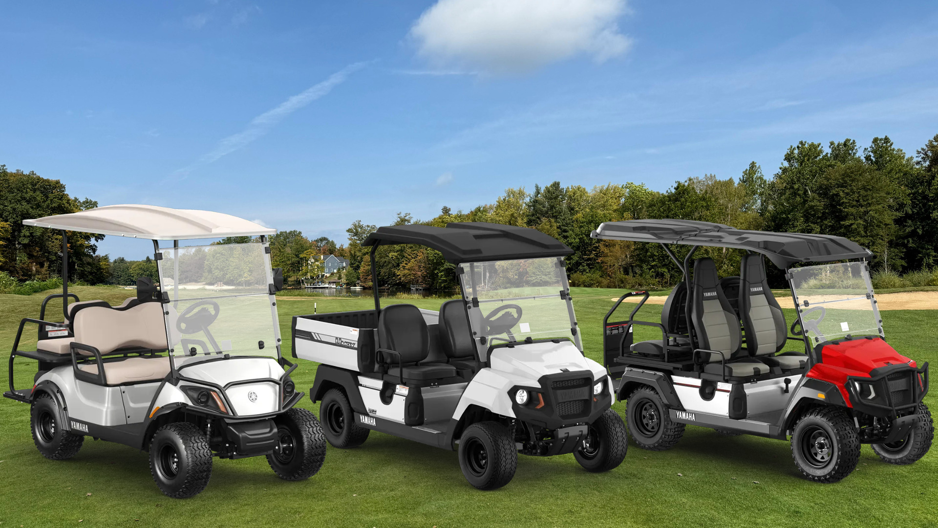 Three Yamaha golf and utility carts displayed on a grassy golf course.