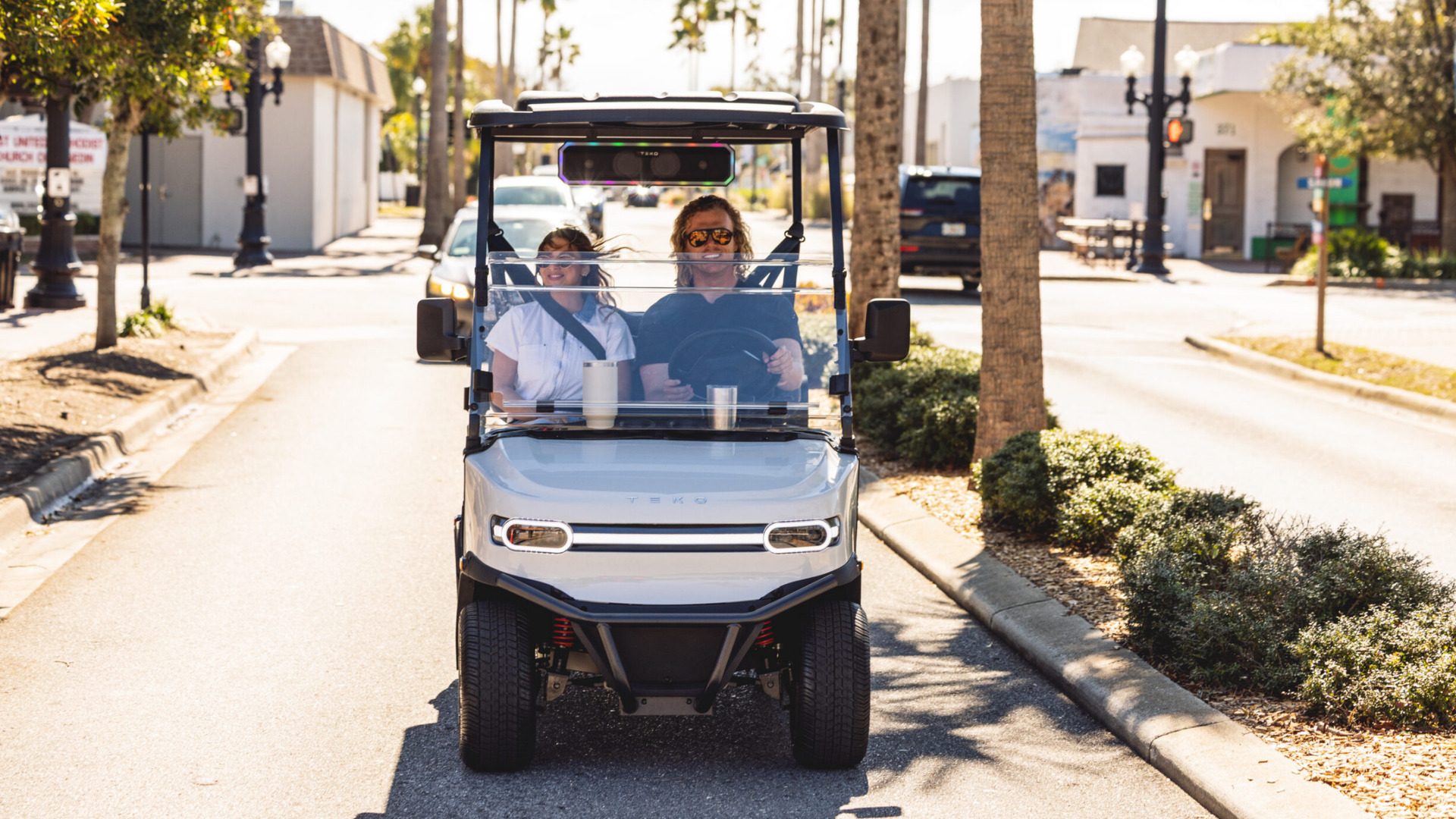2026 Teko Turbolite driving through Corona streets with two passengers in a white golf cart.