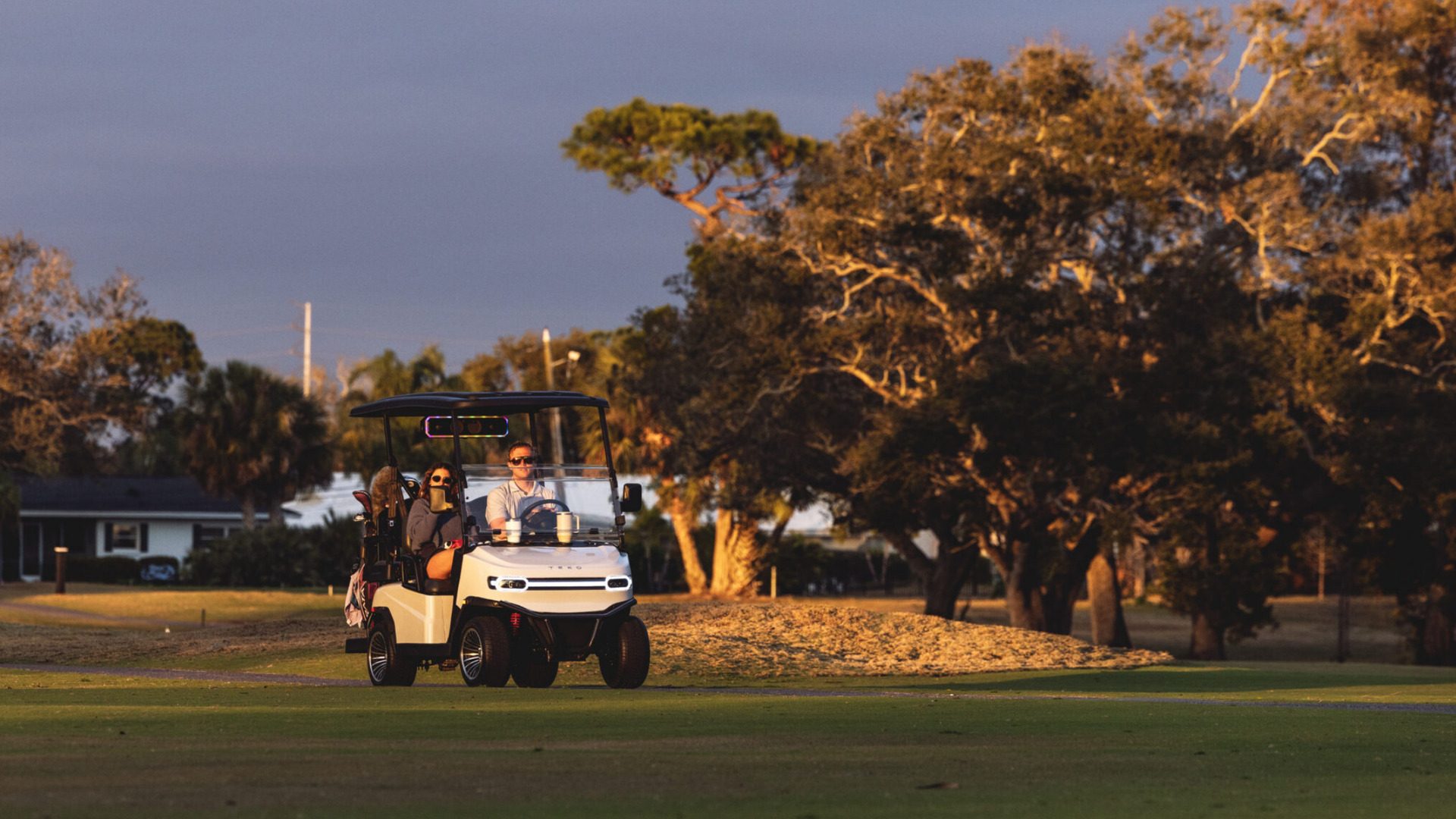 2026 Teko Turbolite golf cart on Phoenix course at sunset with two passengers.