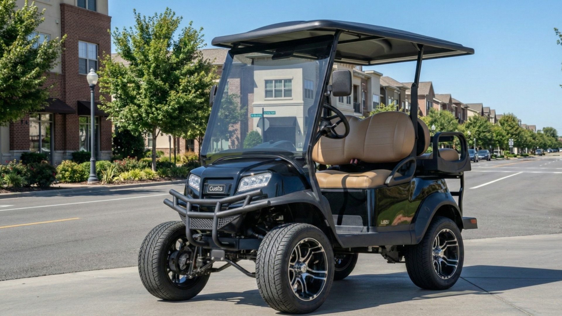 Black golf cart with tan seats parked on a city street in a residential neighborhood.